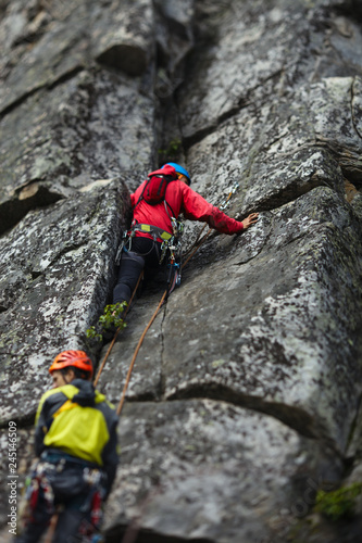 Two rock climbers on a rock wall close-up. Tilt-Shift effect.