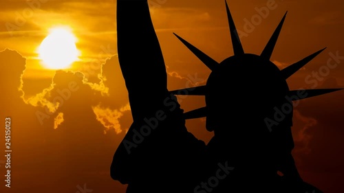 New York: Statue of Liberty at Sunset, with Red Sun, Clouds and the Iconic Sculpture in Silhouette, Manhattan, USA