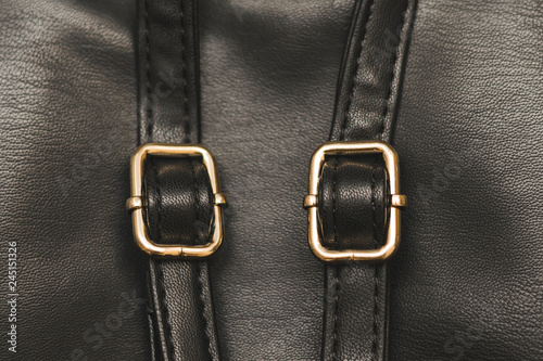 strip of black leather with straps for adjusting