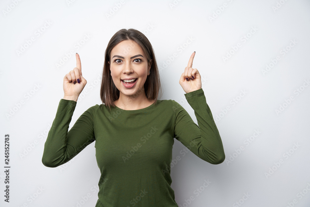 Surprised woman pointing up with two fingers Surprised woman pointing up with two fingers