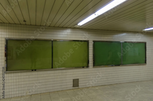 Fototapeta Naklejka Na Ścianę i Meble -  big blank advertising billboard on wall with copy space for your text message or media and content in subway train station or airport, information board, banner, marketing and advertising concept