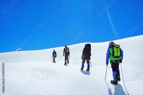 Hikers with backpacks reaches the summit of mountain peak. Success freedom and happiness achievement in mountains. Active sport concept.