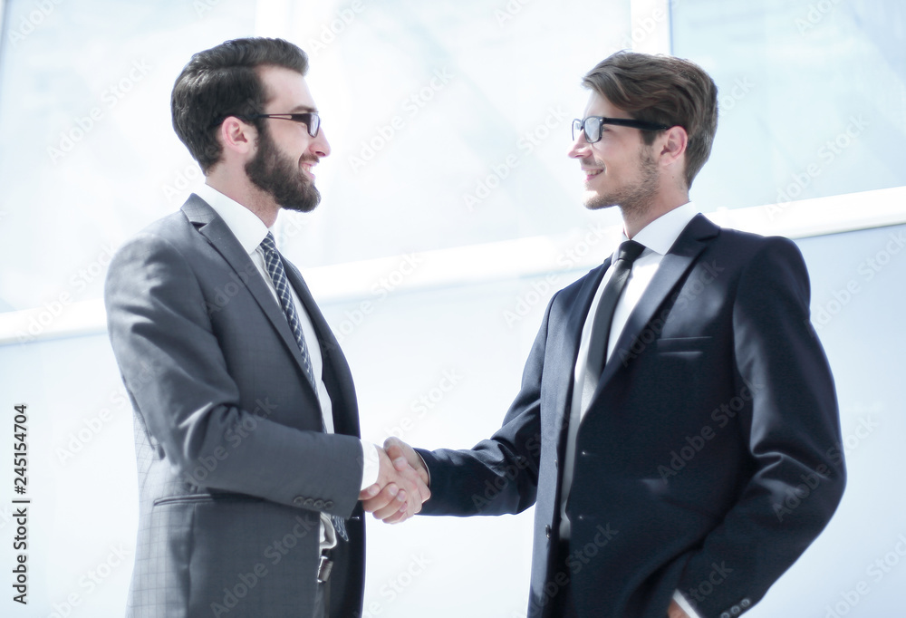 handshake business partners in a bright office