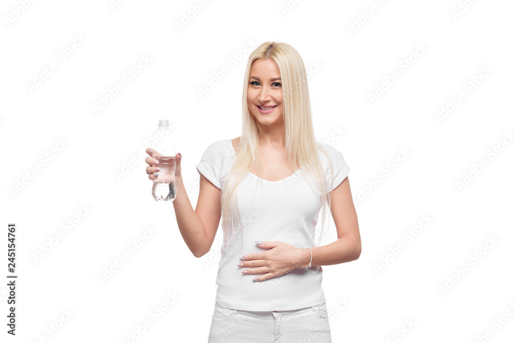 Pleased Blond young woman with bottle of a clear mineral water. girl monitors their health and diets. holding a transparent plastic bottle Pleased Blond young woman with bottle of a clear mineral water. girl monitors their health and diets. holding a transparent plastic bottle
