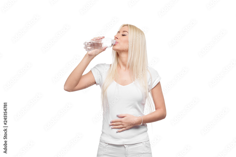 Pleased Blond young woman with bottle of a clear mineral water. girl monitors their health and diets. holding a transparent plastic bottle Pleased Blond young woman with bottle of a clear mineral water. girl monitors their health and diets. holding a transparent plastic bottle
