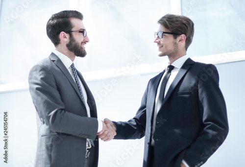 handshake business partners in a bright office