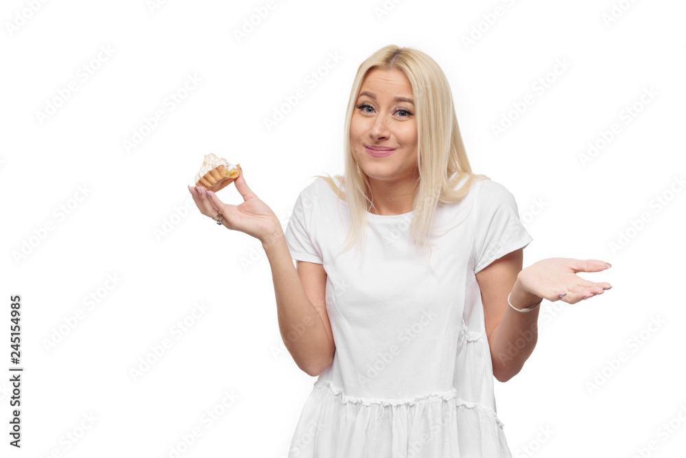 Diet. Dieting concept. Image of beautiful blond woman in white clothe isolated over white background holding and eating cake with pleasure Diet. Dieting concept. Image of beautiful blond woman in white clothe isolated over white background holding and eating cake with pleasure