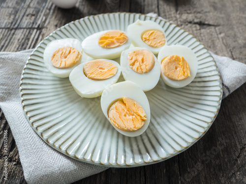 Boiled chicken eggs on a gray plate. Wooden background. The concept of Easter