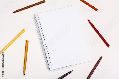 paper and colorful felt tip pens on the white table