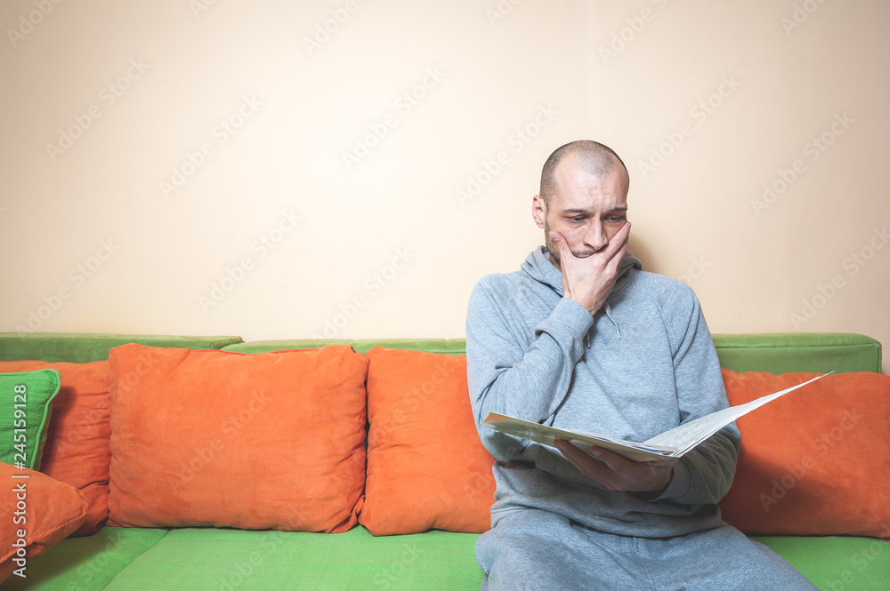 Young or middle age sick man in the casual clothes reading medical results on the papers from his doctor and realize that he have diagnosed a cancer or other sickness Young or middle age sick man in the casual clothes reading medical results on the papers from his doctor and realize that he have diagnosed a cancer or other sickness