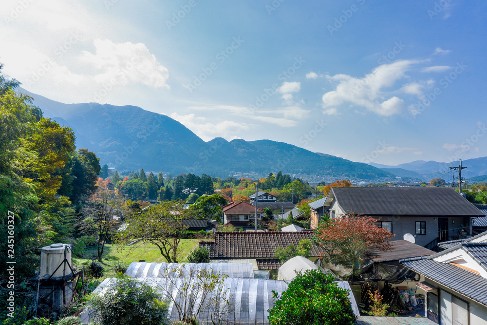 The View of Yufuin countryside with Mount Yufu in Background and blue sky with clouds in autumn season. onsen town, Yufuin, Oita, Kyushu, Japan The View of Yufuin countryside with Mount Yufu in Background and blue sky with clouds in autumn season. onsen town, Yufuin, Oita, Kyushu, Japan
