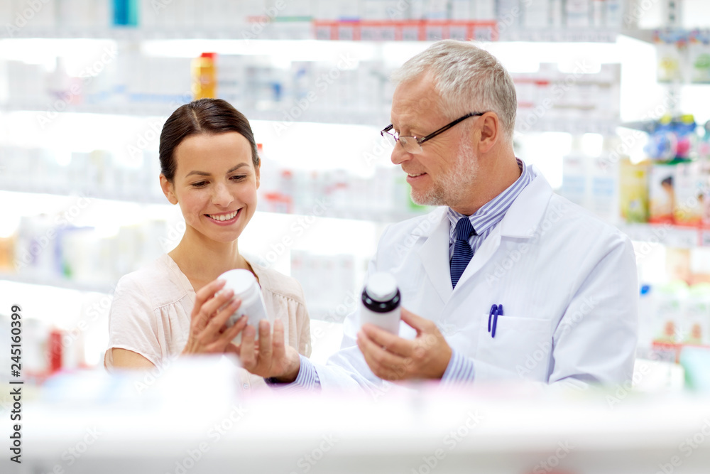 medicine, healthcare and people concept - senior apothecary with drugs and female customer at pharmacy medicine, healthcare and people concept - senior apothecary with drugs and female customer at pharmacy