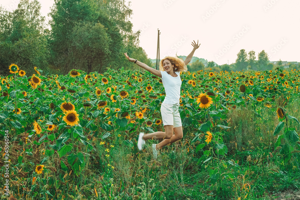 Young pretty woman closeup with sunflower on the field background at summertime Young pretty woman closeup with sunflower on the field background at summertime