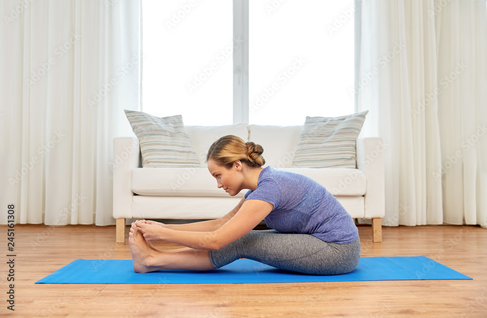 fitness, sport and healthy lifestyle concept - doing yoga exercises on mat at home fitness, sport and healthy lifestyle concept - doing yoga exercises on mat at home