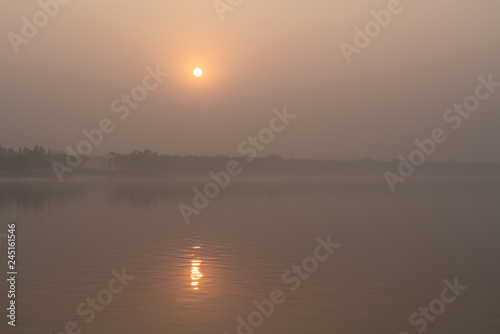 The setting sun in the fog at Sundarbans in West Bengal in India