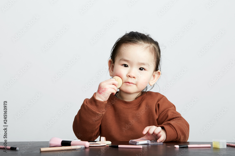 Beautiful cute Asian little girl playing makeup game Beautiful cute Asian little girl playing makeup game