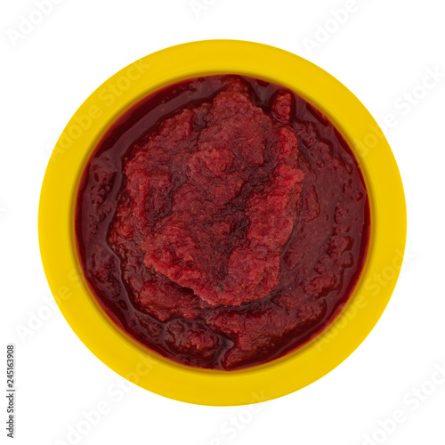 Top view of a bowl of beets and pears baby food isolated on a white background.