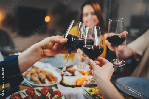 Group of people celebrating anniversary at home, cozy atmosphere, family dining at restaurant with healthy food making cheers with wine glasses, Togetherness Friendship Traditional concept