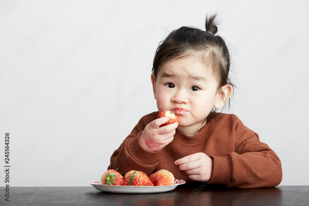 Beautiful cute Asian little girl eating fruits Beautiful cute Asian little girl eating fruits