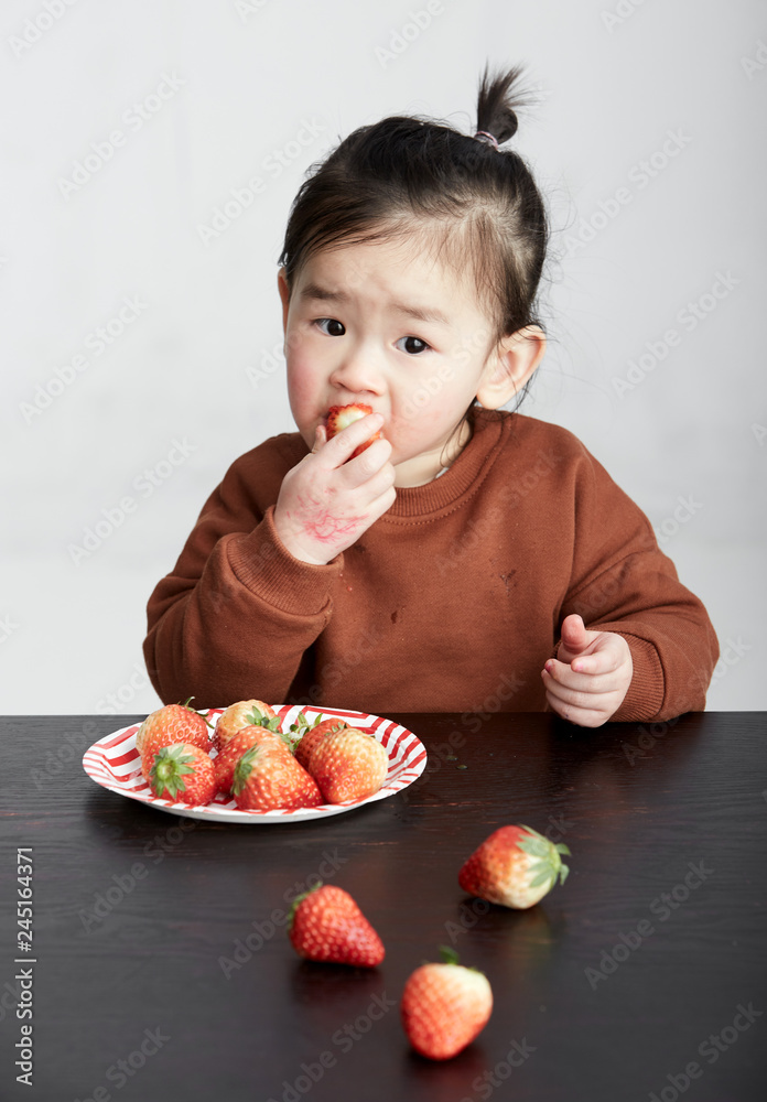 Beautiful cute Asian little girl eating fruits Beautiful cute Asian little girl eating fruits