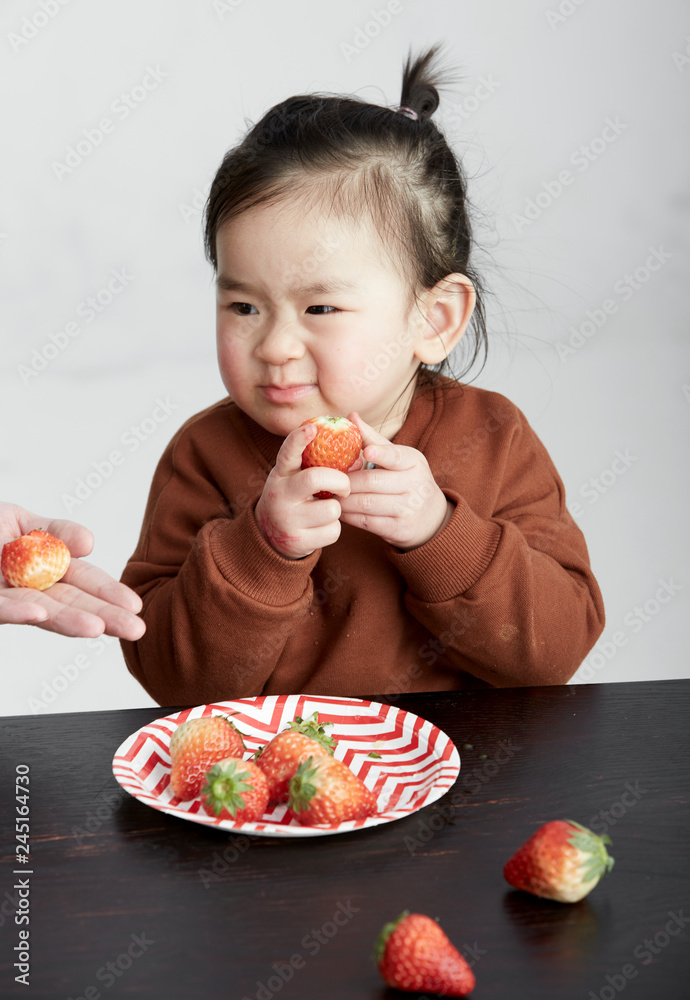 Beautiful cute Asian little girl eating fruits Beautiful cute Asian little girl eating fruits