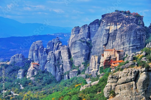 Monastery Meteora Greece. Stunning summer panoramic landscape. mountains and green forest against epic blue sky with clouds UNESCO heritage list object. Aerial view Great Meteor and Rousanou Monastery