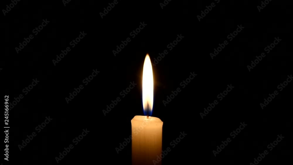 Candle flame on black background. Light candle burning. The concept of mourning, grief or sorrow. Central location. There is a bit of smoke. Candle flame on black background. Light candle burning. The concept of mourning, grief or sorrow. Central location. There is a bit of smoke.
