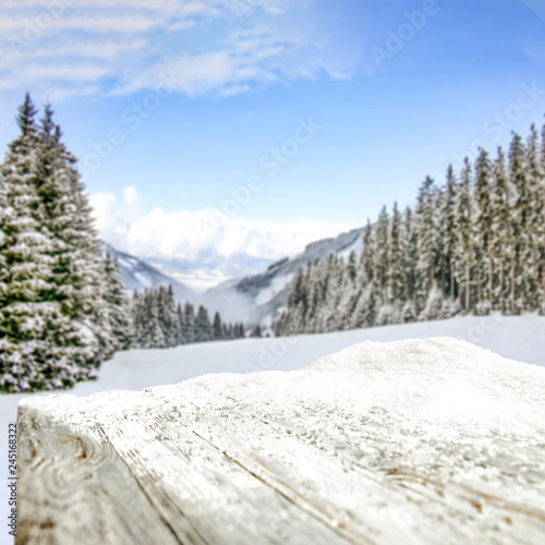 Table background of free space and winter landscape of trees and mountains. 