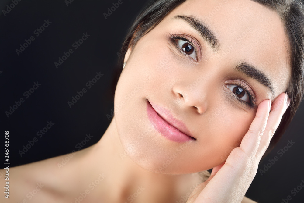 Beauty young girl gently holds her hand near her cheek. Studio shot on black background Beauty young girl gently holds her hand near her cheek. Studio shot on black background