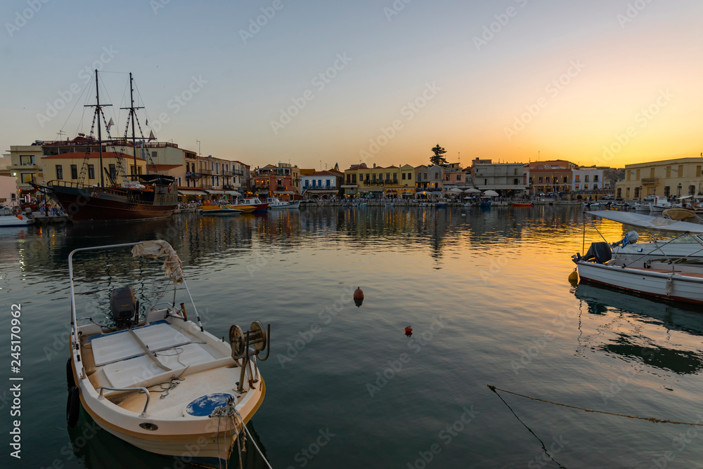 Greece, Crete Rethymnon. Old venetian harbor at the sunset. Panoramic view on the port and sailing ship.