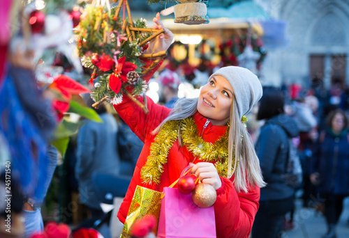 Happy girl chooses Christmas toys on the street market