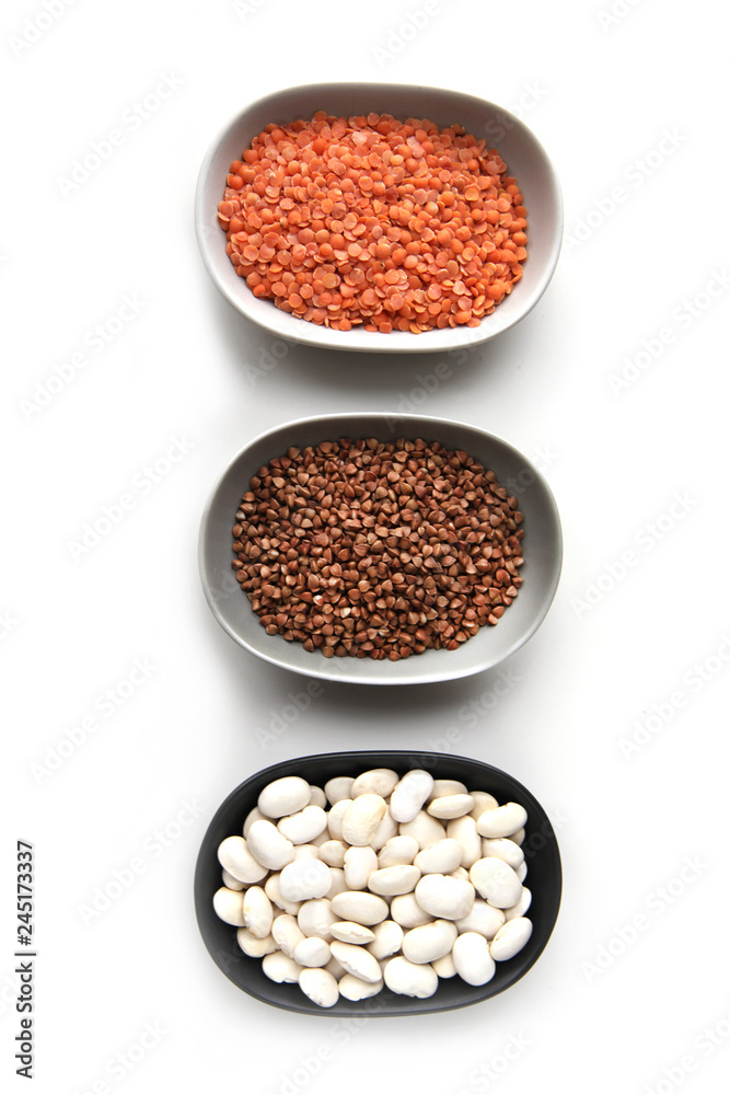 Collection of different groats isolated on black background. Top view of chickpeas, buckwheat, beans in bowls. Collection of different groats isolated on black background. Top view of chickpeas, buckwheat, beans in bowls.