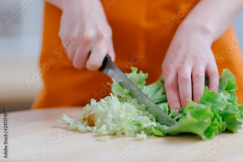 Cook holds knife in hand and cuts on cutting