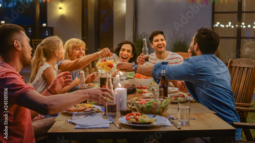 Canvas Print Group of Friends Gathered Together at the Table Relatives and Friends, Young and Elderly are Eating, Drinking, Passing Dishes, Joking and Having Fun