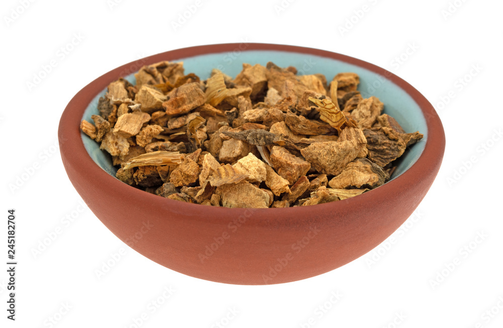 Gentian root in a small bowl on a white background Gentian root in a small bowl on a white background