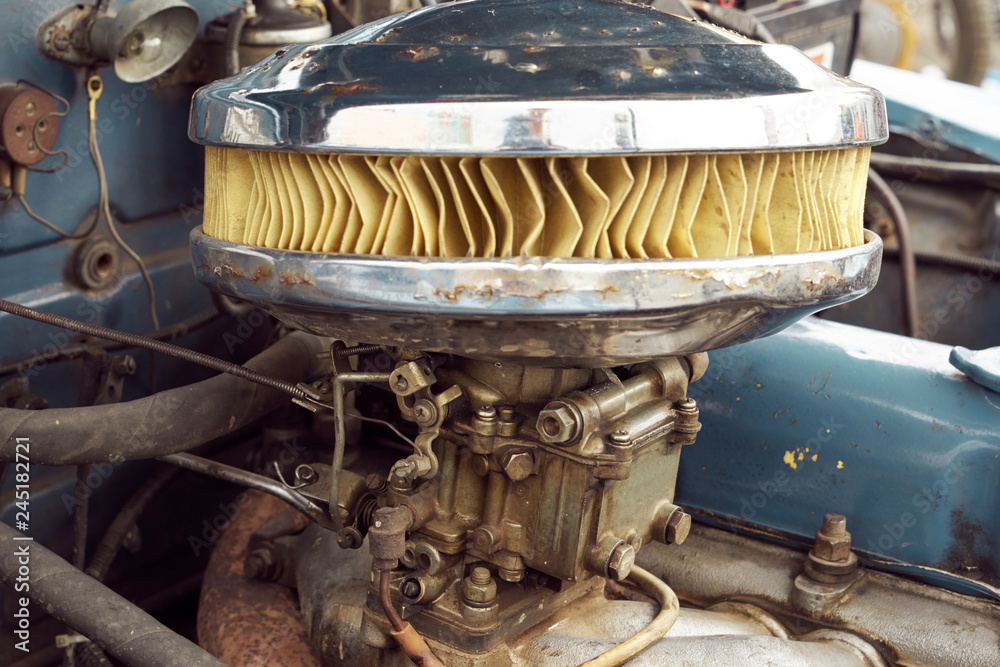 An image of a carburetor and an air filter of an old car. Photos | Adobe  Stock