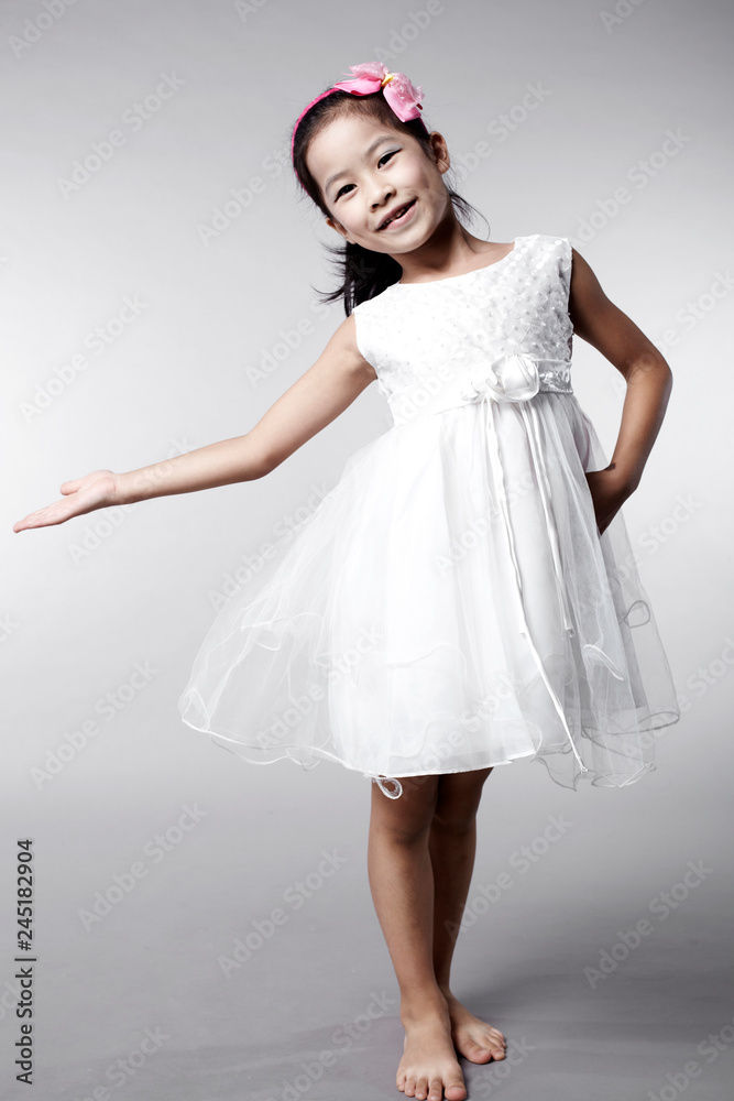 Cute Asian Chinese little girl indoors against white background Cute Asian Chinese little girl indoors against white background