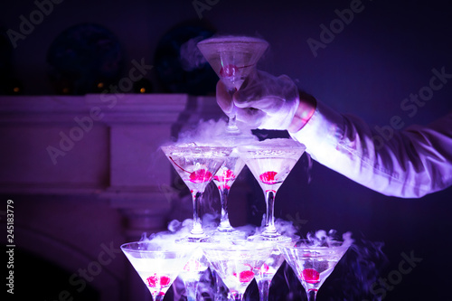 Pyramid of champagne with liquid nitrogen. Colorful  lights