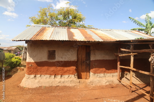 prosta afrykańska chata z gliny i blachy falistej w afryce photo