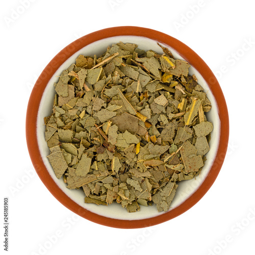 Small bowl filled with eucalyptus leaf on a white background © Bert Folsom