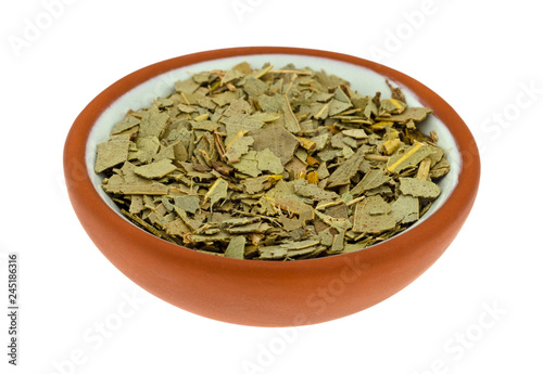 Small bowl filled with eucalyptus leaf on a white background