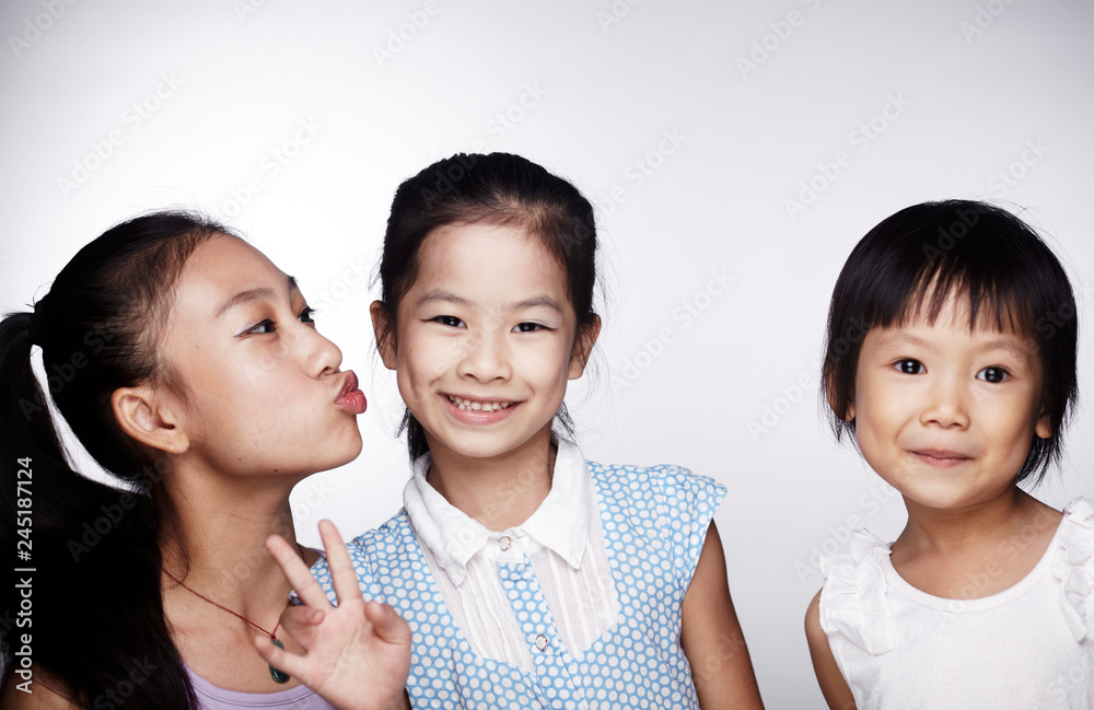Three beautiful cute Asian little girls happily interacting indoors Three beautiful cute Asian little girls happily interacting indoors