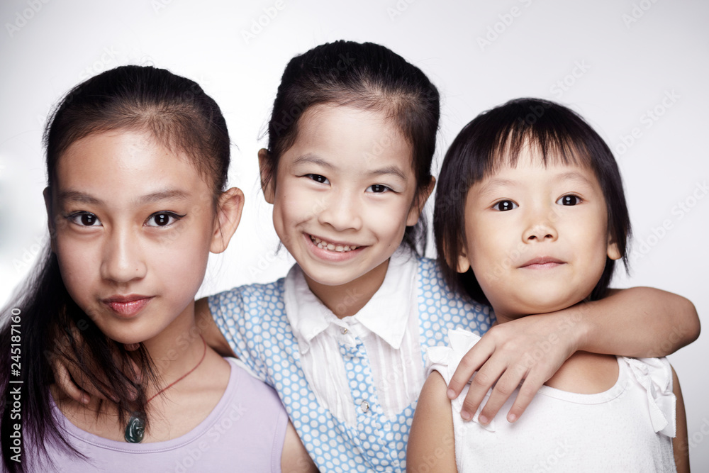 Three beautiful cute Asian little girls happily interacting indoors Three beautiful cute Asian little girls happily interacting indoors