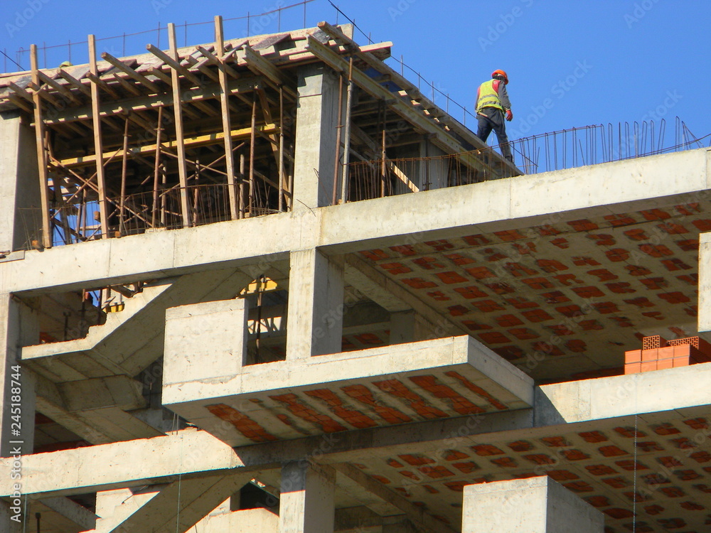 Construction worker on top of a residential building under construction, Tirana, Albania