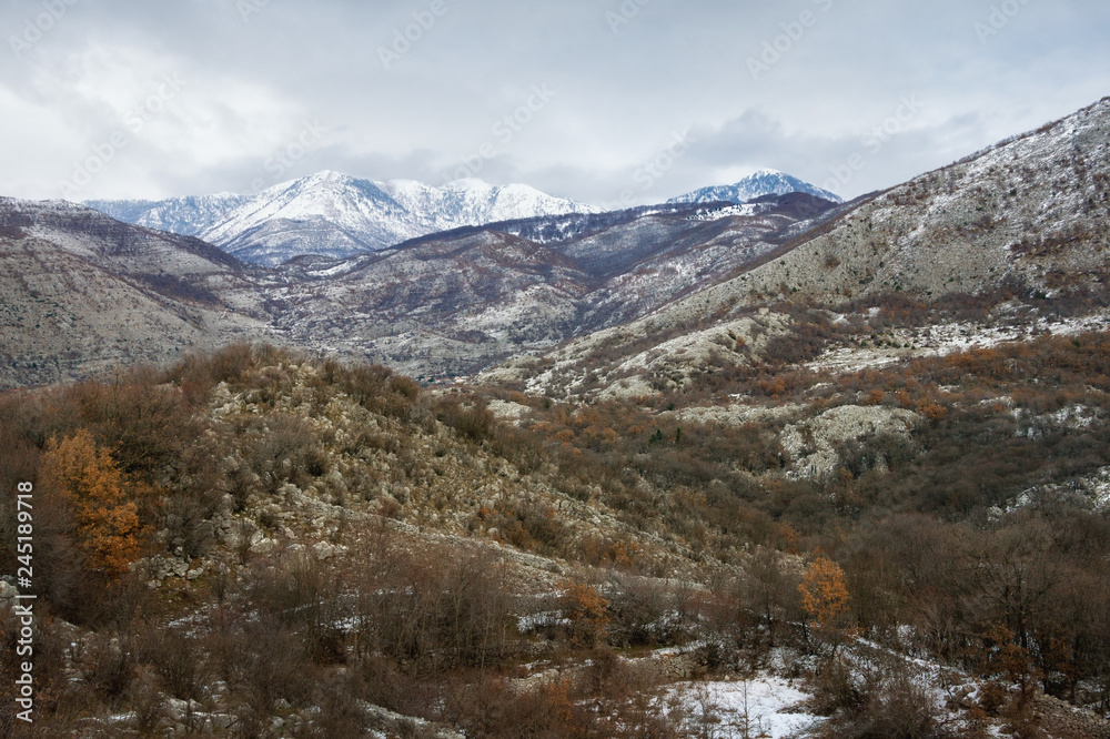 View of mountain range of Dinaric Alps  on cloudy winter day. Montenegro, Sitnica region