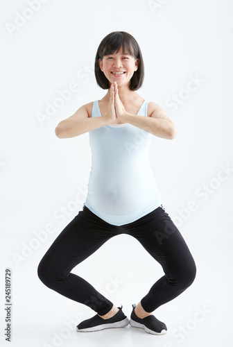 Asian pregnant woman drinking water white background in studio