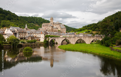Estaing and its medieval castle reflected in the calm waters of the river Lot