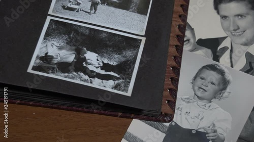 Foreground slow motion of Browsing a vintage photo album with family in Italy