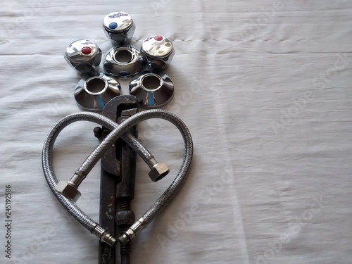 flowers for St. Valentine's Day from the plumber in love heart from water hoses in a metal braid, a sanitary adjustable spanner, flowers from cranes blue and red, metal lids on pipes, beautifully, iso
