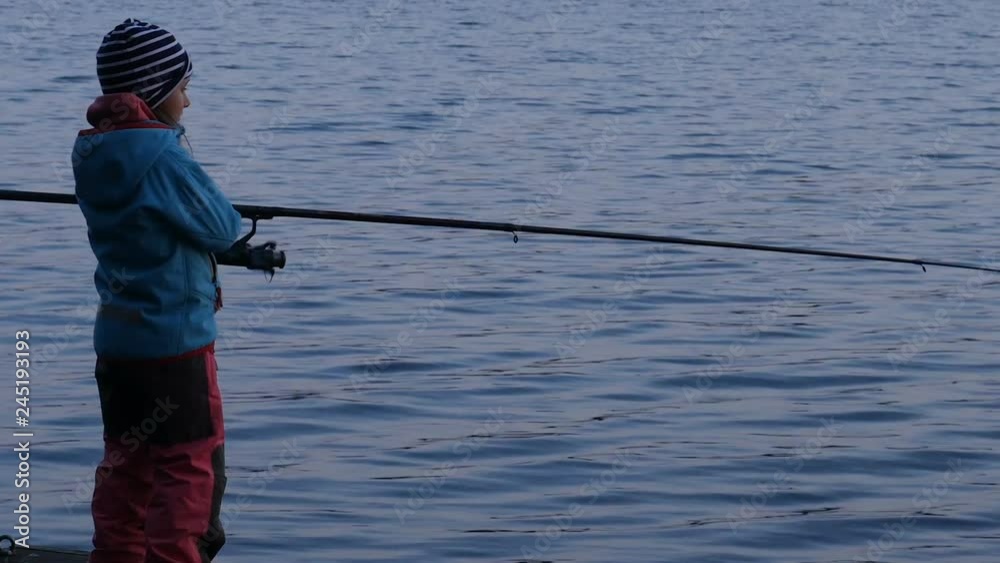 Kid fishing at dusk, silhouette of a little girl with rod fishing Kid fishing at dusk, silhouette of a little girl with rod fishing